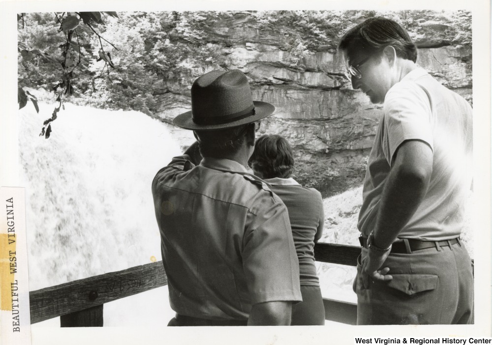 ["Governor Jay Rockefeller listening to a park ranger talk on an overlook at Blackwater Falls."]%